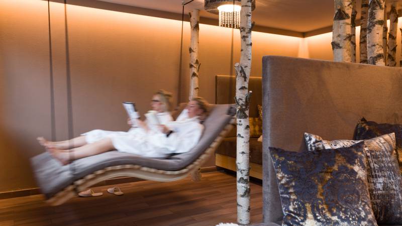 Personen liegen auf Hängeliege im Bademantel und lesen